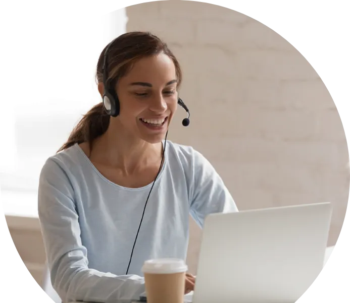 Una mujer sonriente con auriculares trabajando con un portátil